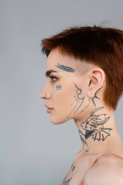 Profil de jeune femme tatouée isolée sur gris — Photo de stock