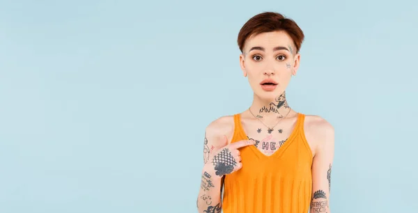 Femme choquée avec tatoué pointant vers elle-même isolé sur bleu, bannière — Photo de stock