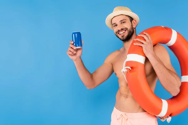 Без сорочки чоловік тримає рятувальний жилет і консервований напій ізольовано на синьому — стокове фото