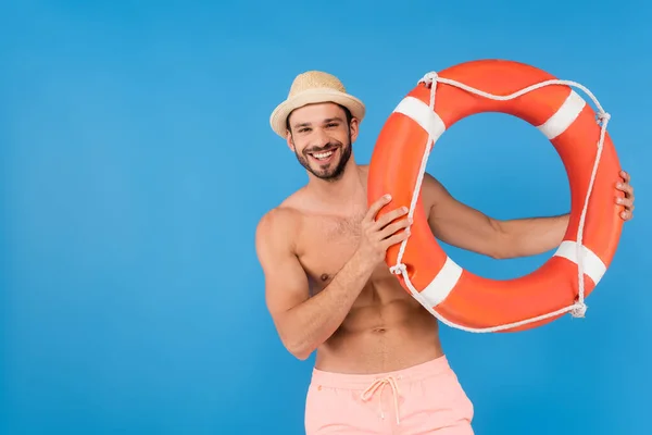 Positiver hemdloser Mann hält Rettungsboje isoliert auf blauem Grund — Stockfoto