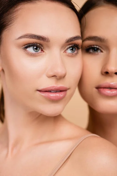 Closed up view of young woman with perfect skin near blurred friend isolated on beige — Stock Photo