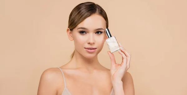 Young woman with perfect skin and natural makeup holding perfume isolated on beige, banner — Stock Photo