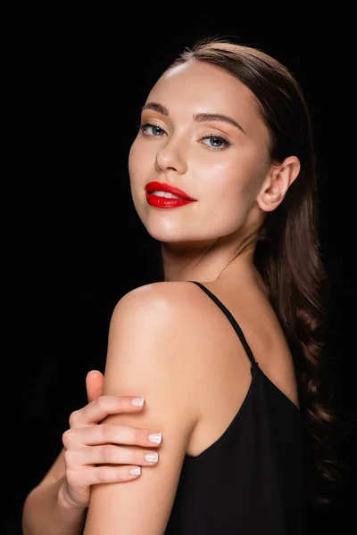 Seductora mujer con labios rojos brillantes posando aislada sobre negro - foto de stock