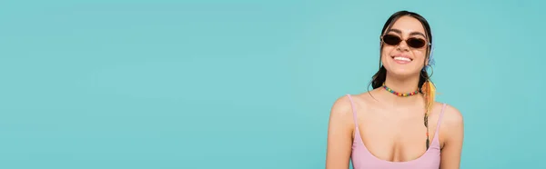 Femme heureuse en collier et lunettes de soleil isolées sur bleu, bannière — Photo de stock