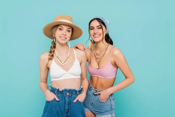 Smiling women in tops and necklaces isolated on blue — Stock Photo