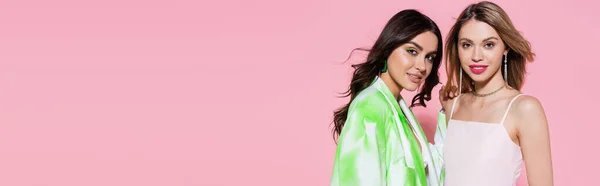 Happy women in trendy clothes smiling at camera on pink background, banner — Stock Photo