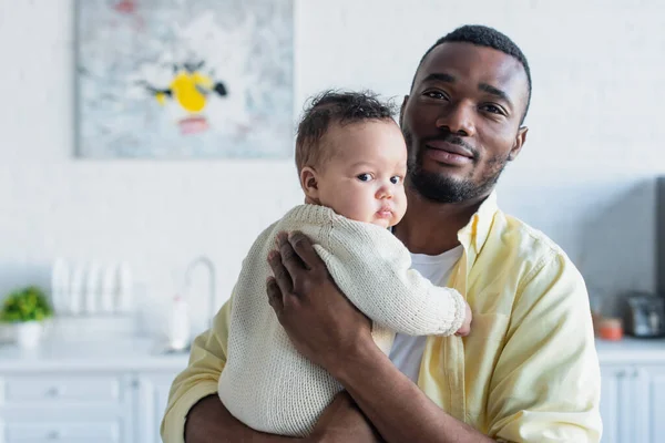 Africano americano uomo abbracciare bambino ragazza a casa — Foto stock
