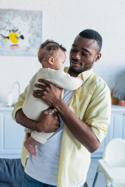 Africano ameican padre holding bambino ragazza in mano in cucina — Foto stock