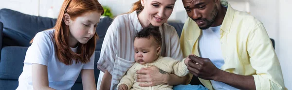 Afro-americano homem tocando mão de criança filha perto da família, bandeira — Fotografia de Stock