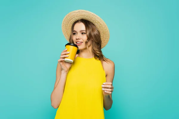 Pretty woman in straw hat holding takeaway drink isolated on blue — Stock Photo