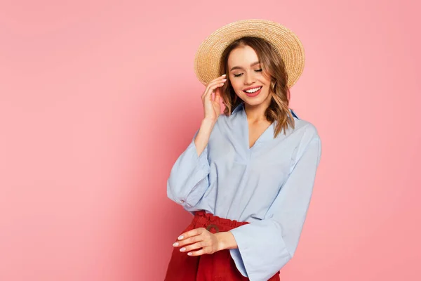 Pretty woman in sun hat posing on pink background — Stock Photo