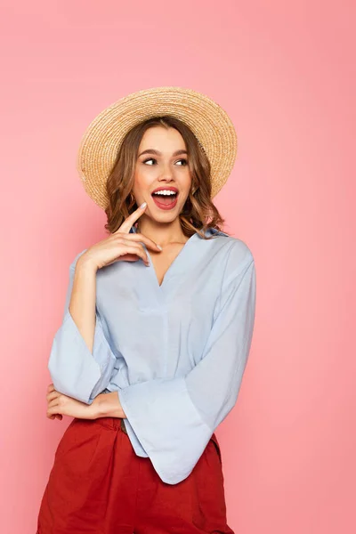 Excited woman in straw hat looking away isolated on pink — Stock Photo