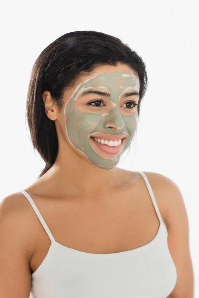 Giovane donna afroamericana con maschera di fango sul viso distogliendo lo sguardo su sfondo bianco — Foto stock