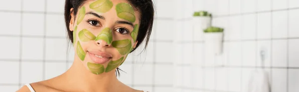 Jovem com máscara verde no rosto olhando para a câmera no banheiro, banner — Fotografia de Stock