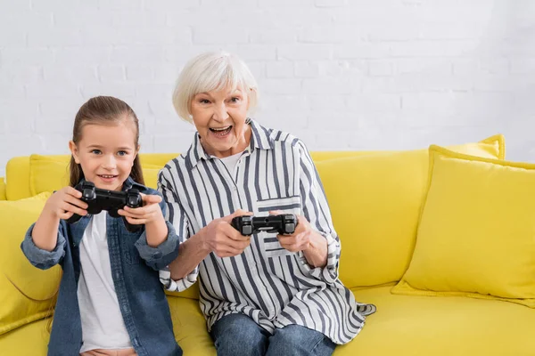 KYIV, UCRANIA - 11 de enero de 2021: Abuela y niño jugando videojuegos durante la competencia - foto de stock