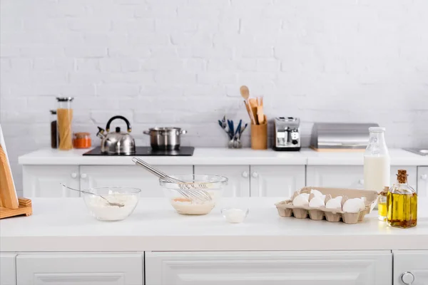 Ovos, leite e farinha perto de tablet digital na mesa da cozinha — Fotografia de Stock