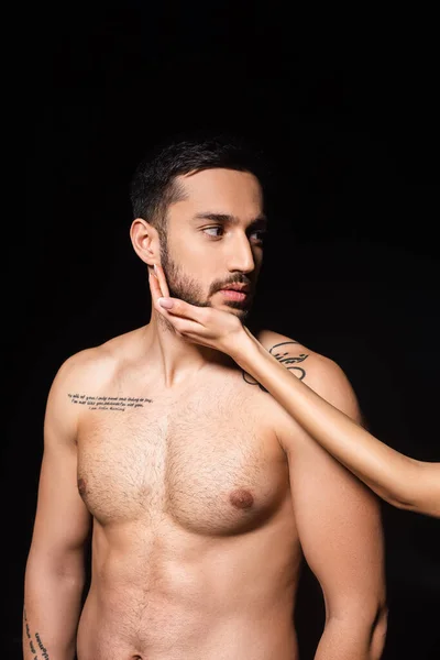 Жінка торкається бороди татуйованого хлопця ізольовано на чорному — стокове фото