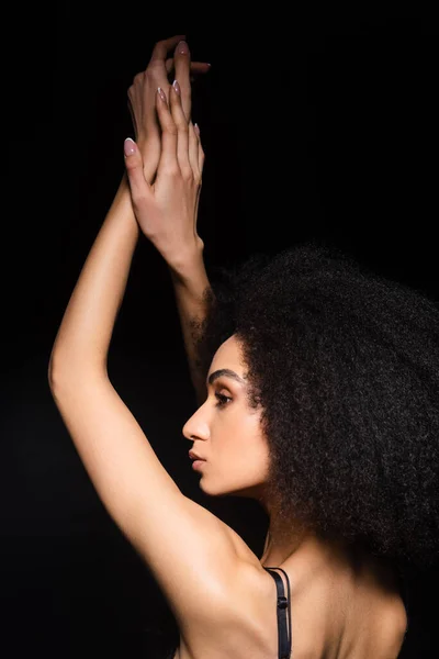 Vista laterale della donna afroamericana in reggiseno isolato su nero — Foto stock