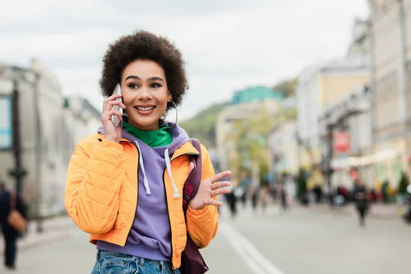 Sourire femme afro-américaine parlant sur smartphone dans la rue urbaine — Photo de stock