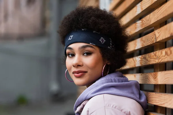 Femme afro-américaine élégante près d'une clôture en bois — Photo de stock