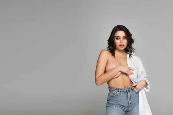 Чуттєва жінка з голим бюстом позує ізольовано на сірому — стокове фото