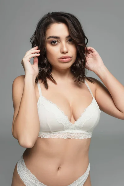 Jolie brune femme en lingerie regardant la caméra isolée sur gris — Photo de stock