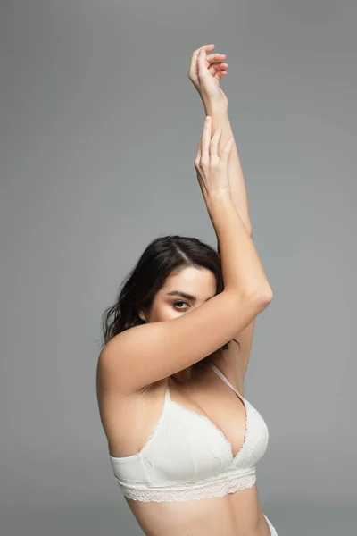 Woman in bra covering face isolated on grey — Stock Photo