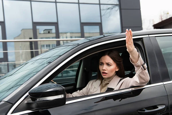 Сердита жінка жестикулює під час водіння автомобіля в місті — стокове фото