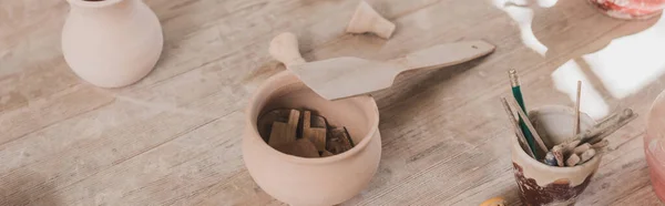 Vue grand angle des pots en argile faits à la main avec spatule sur table en bois en poterie, bannière — Photo de stock