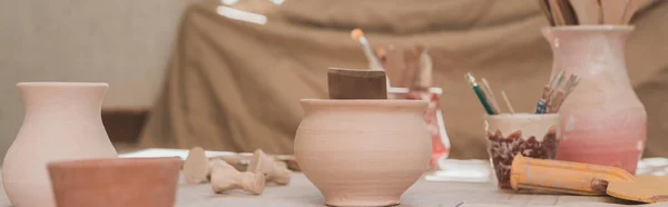 Pots en argile faits à la main avec équipement de poterie sur table en bois, bannière — Photo de stock