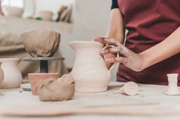 Partial view of young african american woman touching clay pot in pottery — Stock Photo