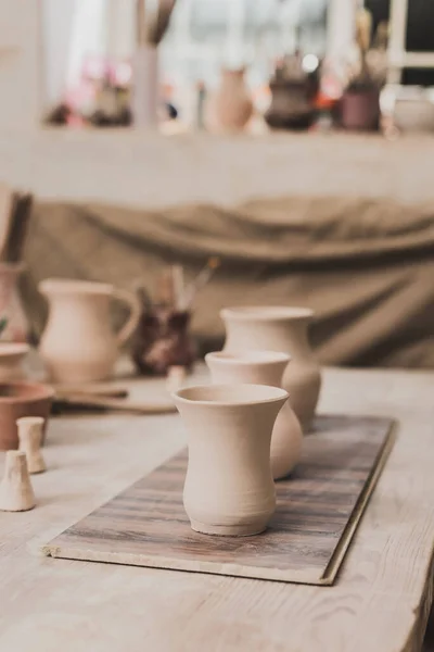 Vasos de barro artesanais e equipamentos de cerâmica em mesa de madeira — Fotografia de Stock