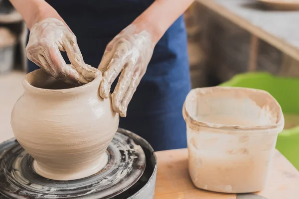 Vue rapprochée de la jeune femme afro-américaine façonnant pot d'argile humide sur roue avec les mains en poterie — Photo de stock