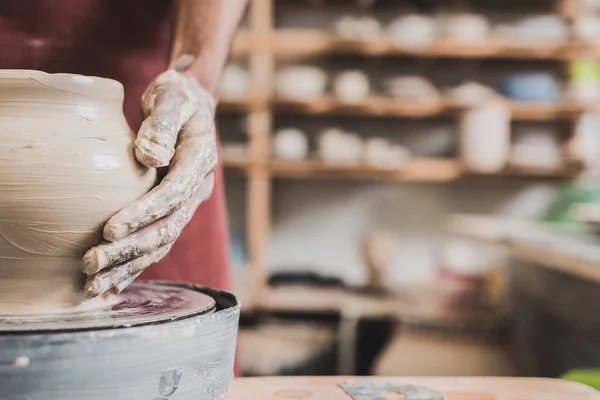 Vista parziale di giovane uomo africano americano modellare pentola di argilla bagnata su ruota in ceramica — Foto stock