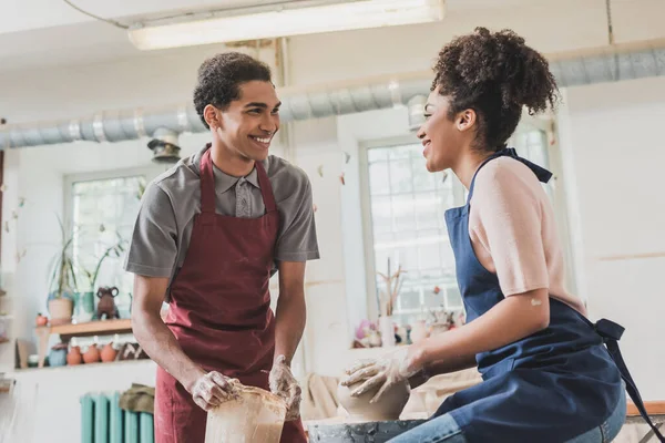 Sourire jeune couple afro-américain sculptant pot sur roue en poterie — Photo de stock