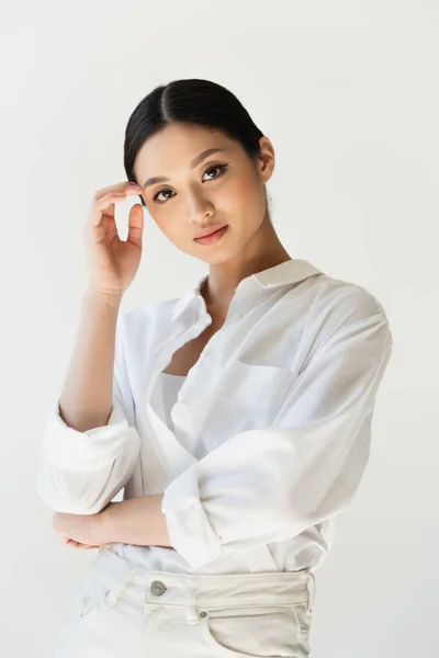 Asian woman in white clothes looking at camera isolated on grey — Stock Photo