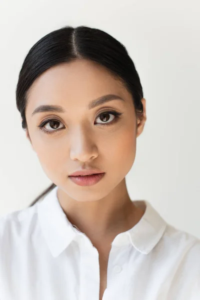 Portrait of asian woman looking at camera isolated on grey — Stock Photo