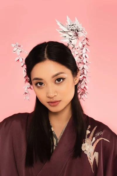 Jeune femme asiatique avec coiffure traditionnelle isolée sur rose — Photo de stock