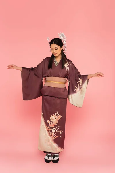 Volle Länge der asiatischen Frau in orientalischer Kleidung stehend auf rosa Hintergrund — Stockfoto