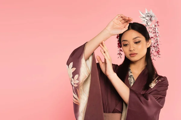 Mujer japonesa bonita en ropa tradicional aislada en rosa - foto de stock