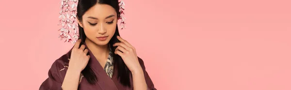 Junge Japanerin in orientalischer Kleidung berührt Haare isoliert auf rosa, Banner — Stockfoto