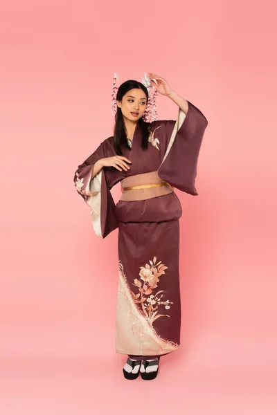 Full length of japanese woman in oriental clothes and footwear on pink background — Stock Photo