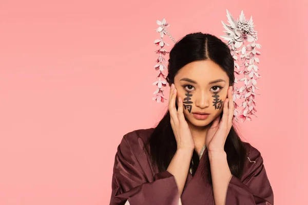 Femme japonaise en kimono avec hiéroglyphes sur le visage isolé sur rose — Photo de stock