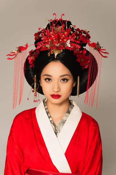 Joven mujer japonesa con peinado tradicional aislado en gris - foto de stock