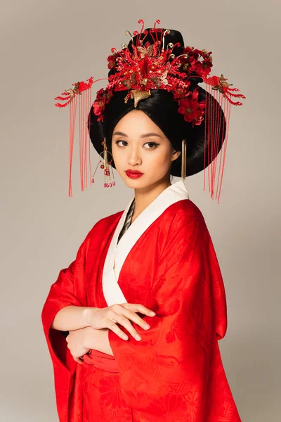 Schöne asiatische Frau mit roten Lippen und traditioneller Kleidung isoliert auf grau — Stockfoto