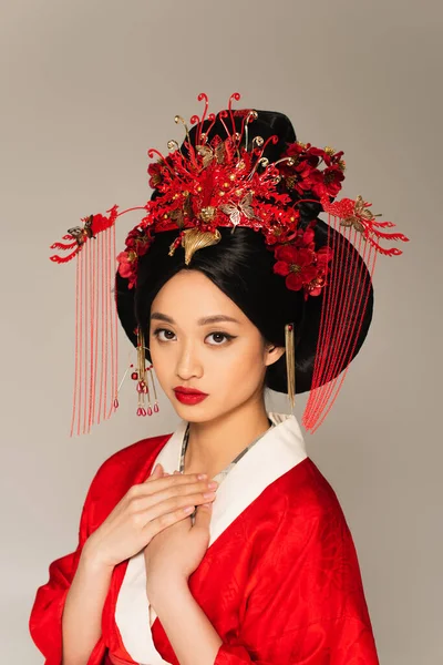 Junge Japanerin in rotem Kostüm blickt vereinzelt auf graue Kamera — Stockfoto