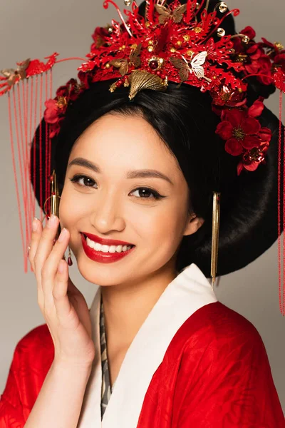 Alegre asiático mujer con rojo labios mirando cámara aislado en gris - foto de stock