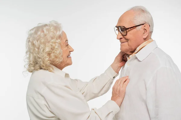 Donna anziana delicatamente toccando uomo anziano con mano isolata su bianco — Foto stock