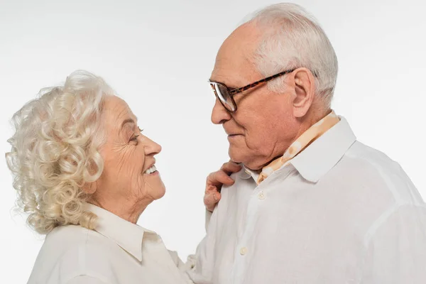 Elderly couple in casual clothes hugging and looking at each other isolated on white — Stock Photo