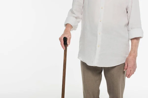 Visão parcial do homem idoso em roupas casuais segurando bengala isolada em branco — Fotografia de Stock